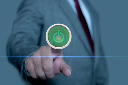 Businessman hand touching power on screen, pushing on a touch screen power button. concept...