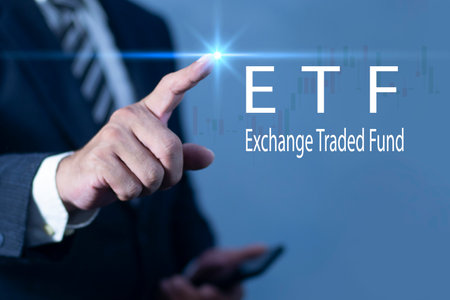 Businessman using smartphone pointing at ETF (Exchange Traded Funds). Investment Opportunities in Mutual Funds and ETFs, Growing Wealth in the Financial Market.の写真素材