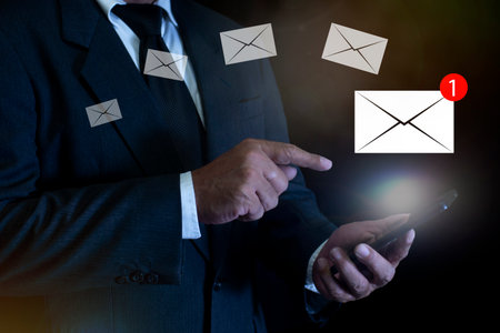 New email notification concept, Businessman using smartphone with email notification for business communication and digital marketing. email newsletter, checking message box, information online.の写真素材