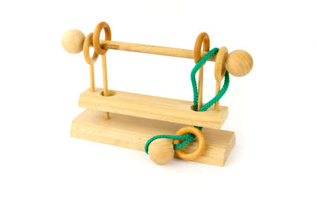 Wooden puzzle with a green cord on a white backgroundの写真素材