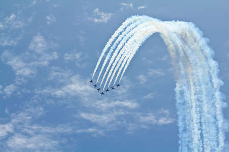 A team of seven airplanes performing difficult maneuver on an air showの写真素材