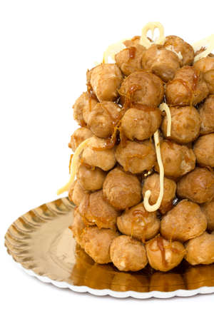 Croquembouche over a golden tray on a white backgroundの写真素材
