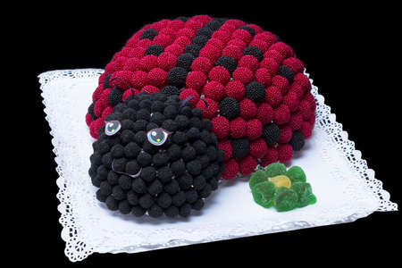 Ladybug cake made of blackberries on a black backgroundの写真素材