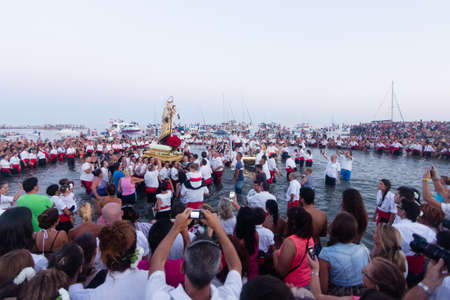 MALAGA, SPAIN - JULY 16: Unidentified local worshipers lift a religious image at the beach during the Virgen del Carmen festival on July 16, 2013 in Malaga, Spain. Virgen del Carmen is the patron saint and protector of fishermen and sailorsのeditorial素材