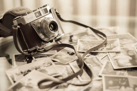 MALAGA, SPAIN - MARCH 6, 2011: Old fashioned Kodak camera with some old pictures over the table.のeditorial素材