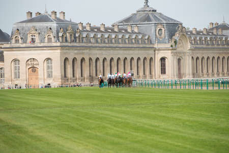 CHATILLY, FRANCE - JUNE 2013: Third Course of the Prize of Diane Longines and Museum of Horse in background on June 16, 2013 in Chantilly. Course name: Grand Handicap Longines.のeditorial素材