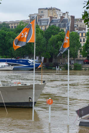 PARIS - JUNE 4: Paris flood with high water on June 4, 2016 in Paris, France. Flags of the parisian boatsのeditorial素材