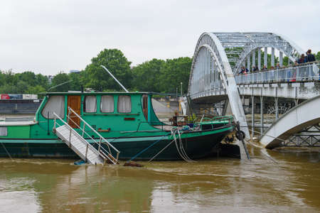 PARIS, FRANCE - JUNE 4: Paris flood with high water on June 4, 2016 in Paris, France. barge and footbridge in the waterのeditorial素材