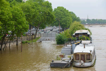 PARIS, FRANCE - JUNE 4: Paris flood with high water on June 4, 2016 in Paris, France. Flooded road and bargeのeditorial素材