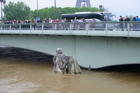 PARIS, FRANCE - JUNE 4: Paris flood with high water on June 4, 2016 in Paris, France.  Zouave statue of the Alma Bridge and people taking photosのeditorial素材