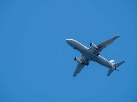 Commercial Tourist airplane flying above blue skyの写真素材