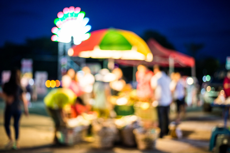 Blurred background of people shopping at night festival with bokehの写真素材