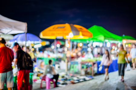 Blurred background of people shopping at night festival with bokehの写真素材