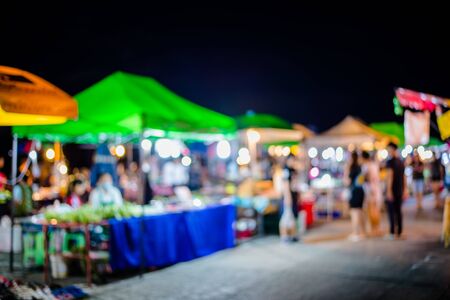 Blurred background of people shopping at night festival with bokehの写真素材