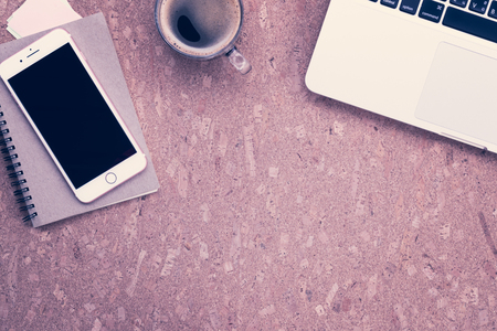 Working desk table concept. Office desk table with laptop, blank paper notebook,cup of coffee and smartphone . Top view with copy space.の写真素材