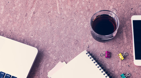 Working desk table concept. Office desk table with laptop, blank paper notebook,cup of coffee and smartphone . Top view with copy space.の写真素材