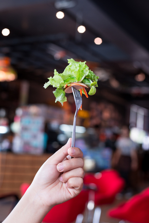 Woman hand holding Salad vegetables on fork.の写真素材