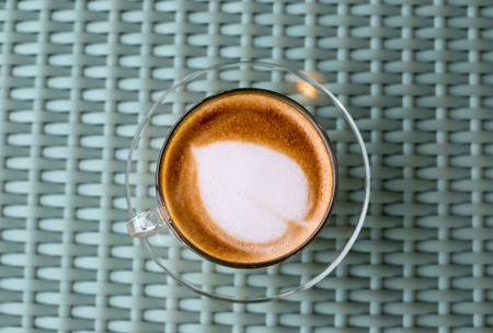 Vintage style of Hot coffee with heart make up on face of milk cream in glass cup on wooden table background, top viewの写真素材