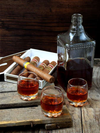 quality cigars and cognac on an old wooden table