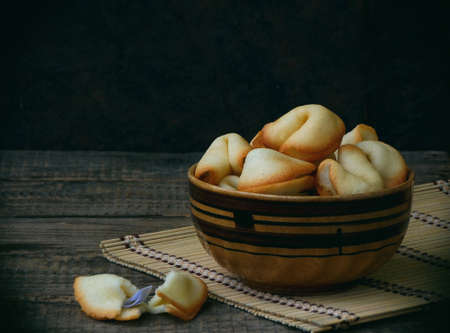 fortune cookies in bowl on a wooden background. Copy space.