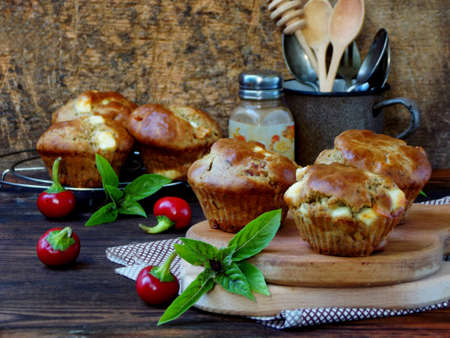 salty snack muffins with feta, pepper and basil on a dark background. selective focusの写真素材