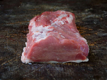 raw piece of pork loin, breast on a wooden background. For steak, roasting, stewing, roasting.の写真素材