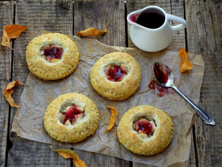 homemade shortbread cakes with apples and jam sprinkled with brown sugar on wooden backgroundの写真素材