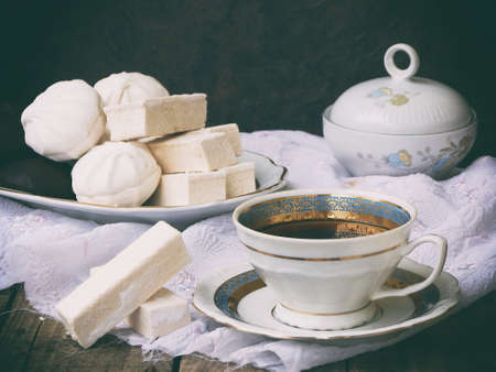 Sweet white Russian marshmallow - zephyr, meringue and cup of coffee on wooden background. Selective focusの写真素材