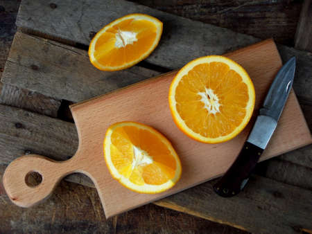 the composition of the cut orange on a wooden board. Selective focusの写真素材