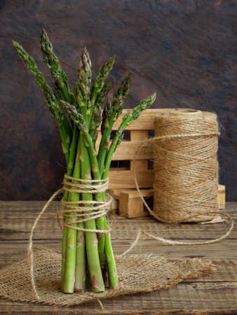 bunch of fresh green asparagus on a wooden backgroundの写真素材