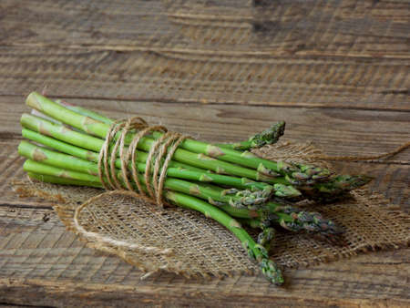 bunch of fresh green asparagus on a wooden backgroundの写真素材
