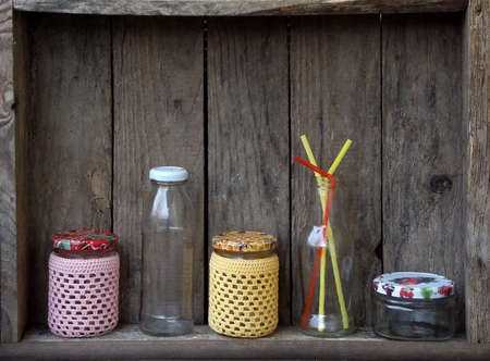 Different empty jar and bottles on wooden background