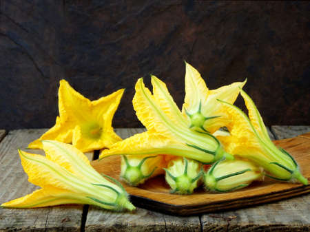 fresh, organic flowers of zucchini on wooden table. rustic style. selective focusの写真素材