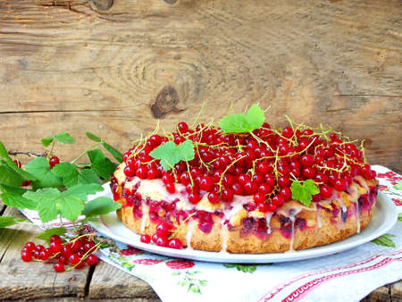 Pie or sponge cake with red currants and poppy seeds on a wooden backgroundの写真素材
