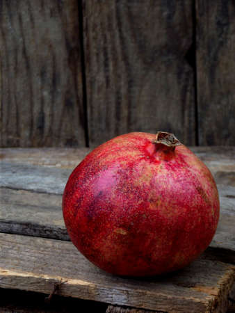 Ripe red pomegranate on a wooden backgroundの写真素材