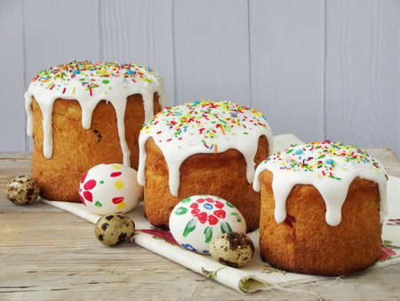 Easter composition of sweet bread, paska and eggs on light wooden background. Orthodox kulich....