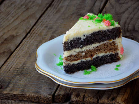 Homemade poppy cake with nut biscuit and custard cream decorated sweets candy on wooden backgroundの写真素材