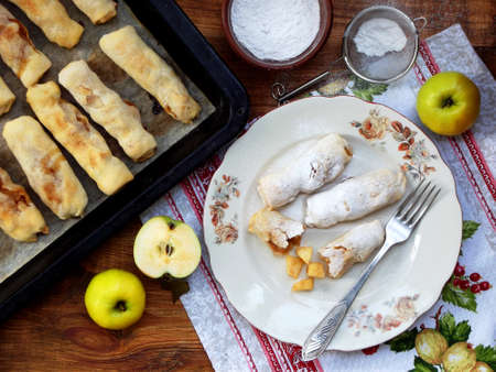 portioned small strudel with apples sprinkled with cinnamon and powdered sugarの写真素材