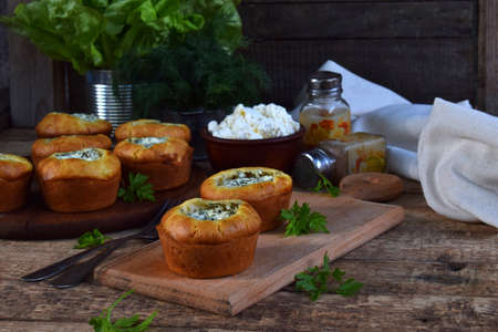 Savory feta cheese muffins with spinach and dill on wooden background. Healthy food concept with copy space for textの写真素材