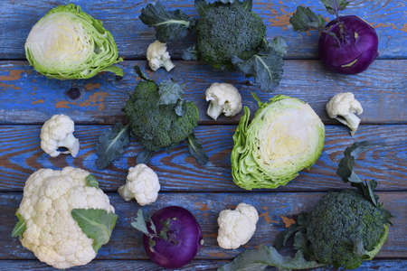 Composition from different varieties of cabbage on wooden background. Cauliflower, kohlrabi, broccoli, white head cabbage. Organic fresh vegetablesの写真素材