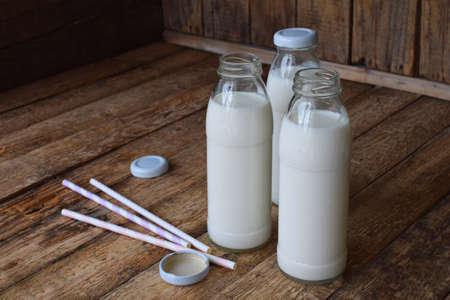 Sour-dairy drink or yoghurt in bottle that come from the kefir grains and milk on wooden background. Photographed with natural light.の写真素材