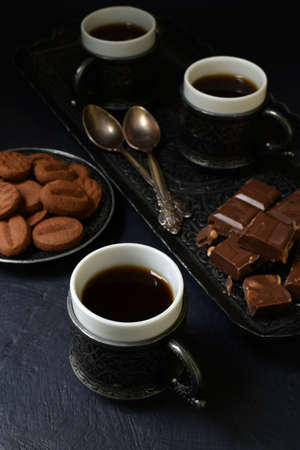 Cups of coffee and chocolate on a dark gray concrete background. Coffee Time in eastern styleの写真素材