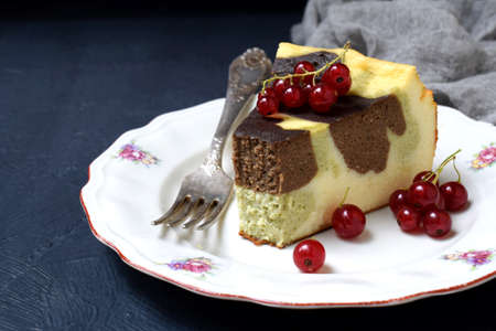 Homemade marble cheesecake with cream cheese, chocolate and tea matcha on a dark background. Copy...