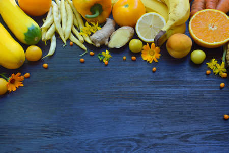 Composition of yellow vegetables and fruits - banana, corn, lemon, plum, apricot, pepper, zucchini, tomato, asparagus beans, ginger Healthy food Top view Flat layの写真素材