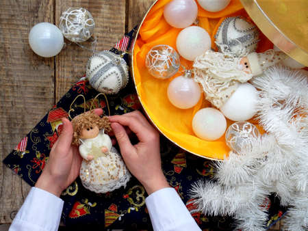 Christmas white balls in box and fairy in hands. Christmas decoration. selective focus.