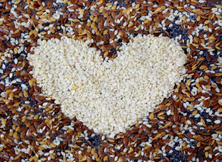 Heart of white sesame on background of different seeds. selective focusの写真素材