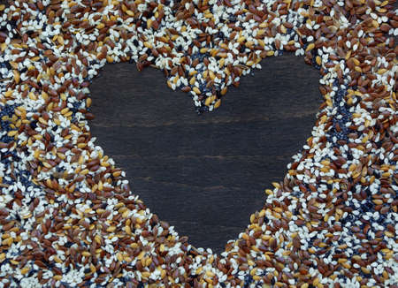 Heart on a background of a poppy seed, flax, sesame. Selective focusの写真素材