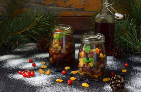 Dried fruits in alcohol, preparation for baking traditional Christmas cake Stollen on dark background. European Xmas traditions. Holiday sweets.の写真素材