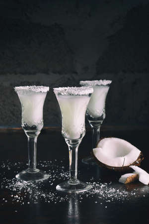 Coconut liqueur in glass with broken coco. Delicious Pinacolada milk cocktail with rum. Alcohol drink liquor. Copy space.の写真素材