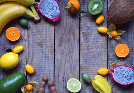 Mix of ripe tropical fruits with avocado, mango, coconut, carambola, banana, kumquat, pitahaya, kiwi Superfood background Vegetarian food Copy spaceの写真素材